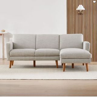 A light gray sofa with wooden legs