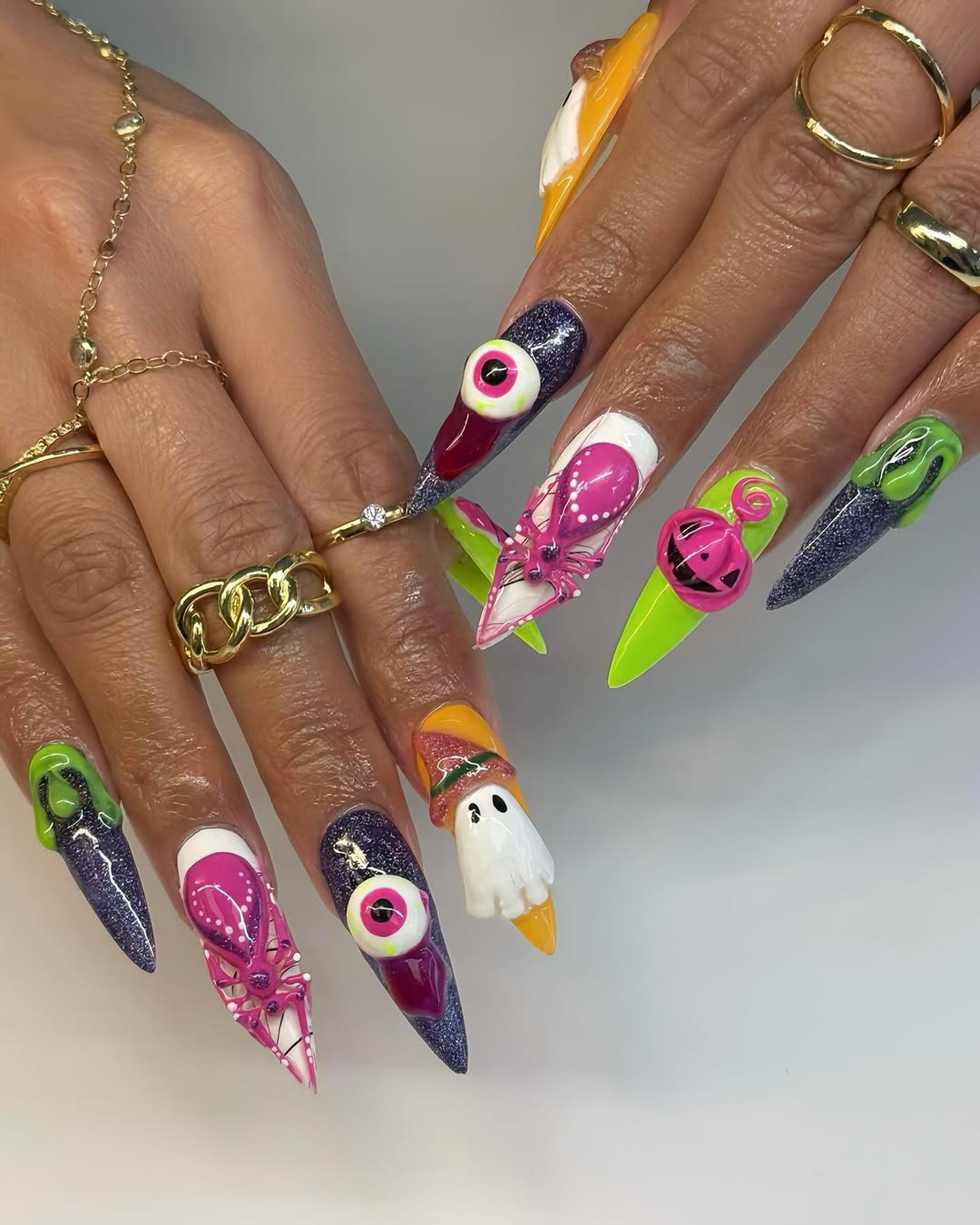 bright halloween nail art with pink, orange, and purple nails