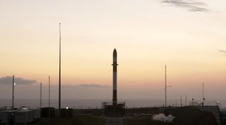 A Rocket Lab Electron booster stands on the pad in New Zealand ahead of the planned Jan. 16 launch of the "Another Leaves the Crust" mission.
