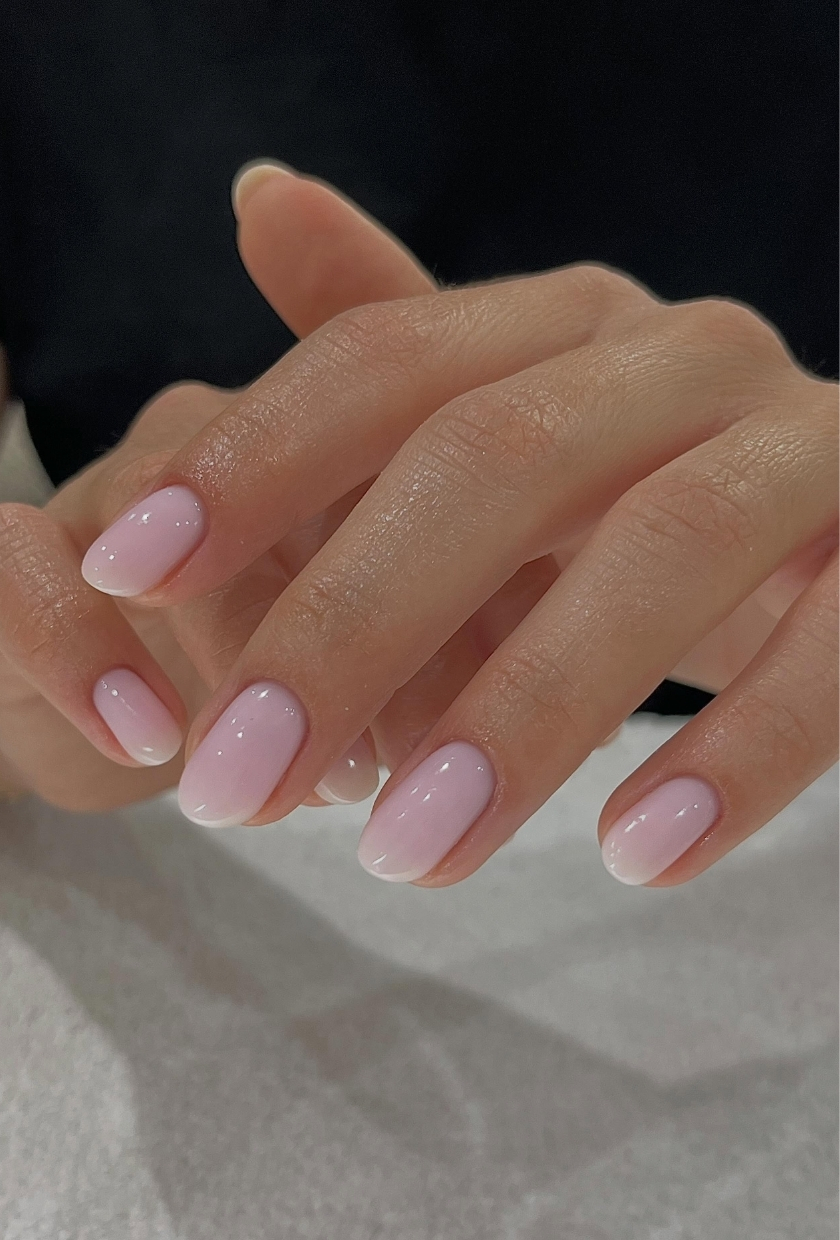 A close-up shot of milky-pink nails