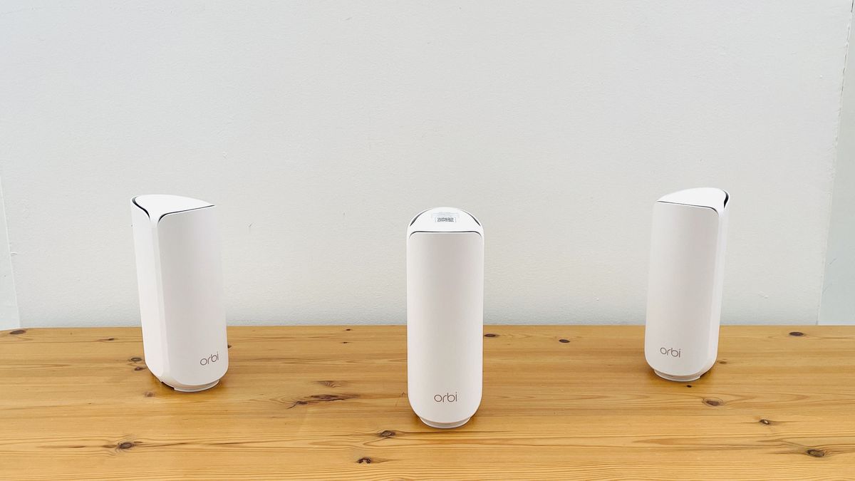 Netgear Orbi 373 with one router and two satellites on a wooden table
