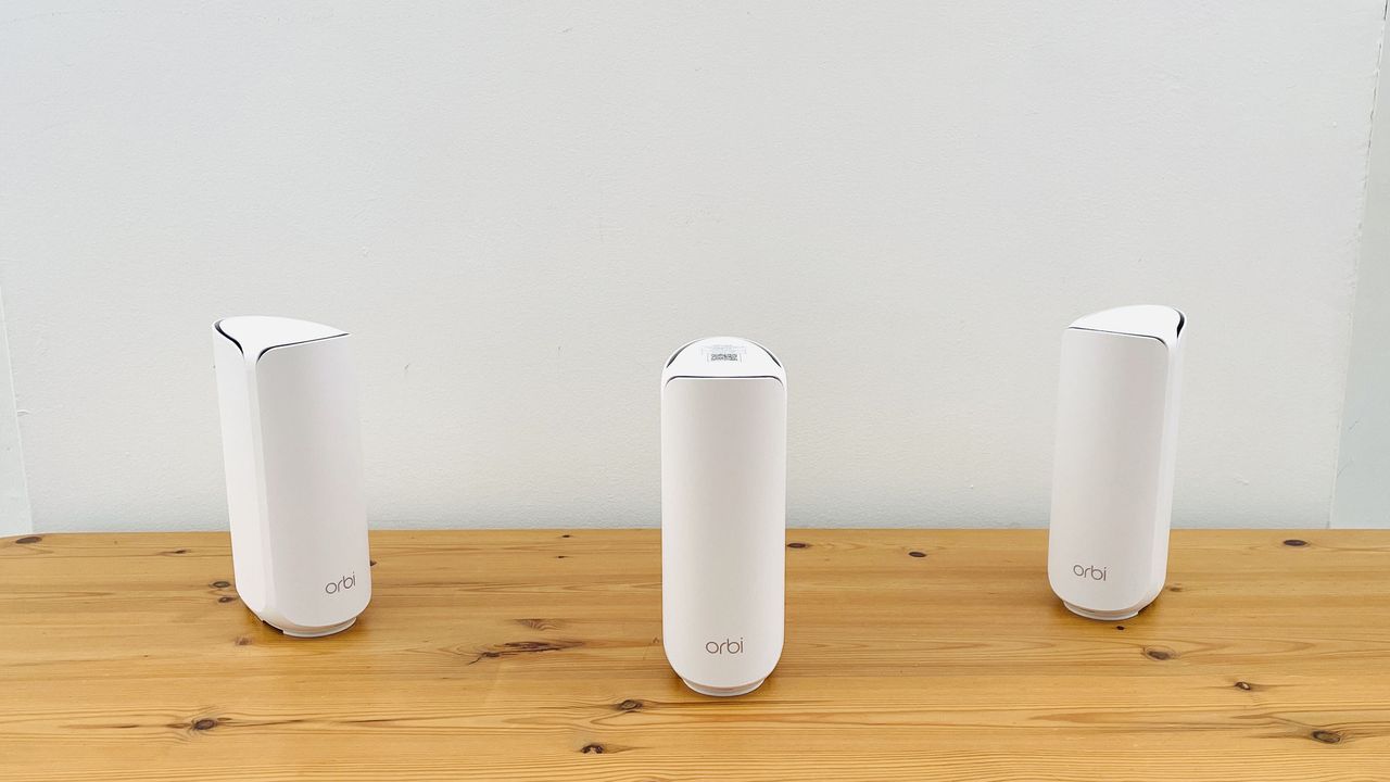 Netgear Orbi 373 with one router and two satellites on a wooden table
