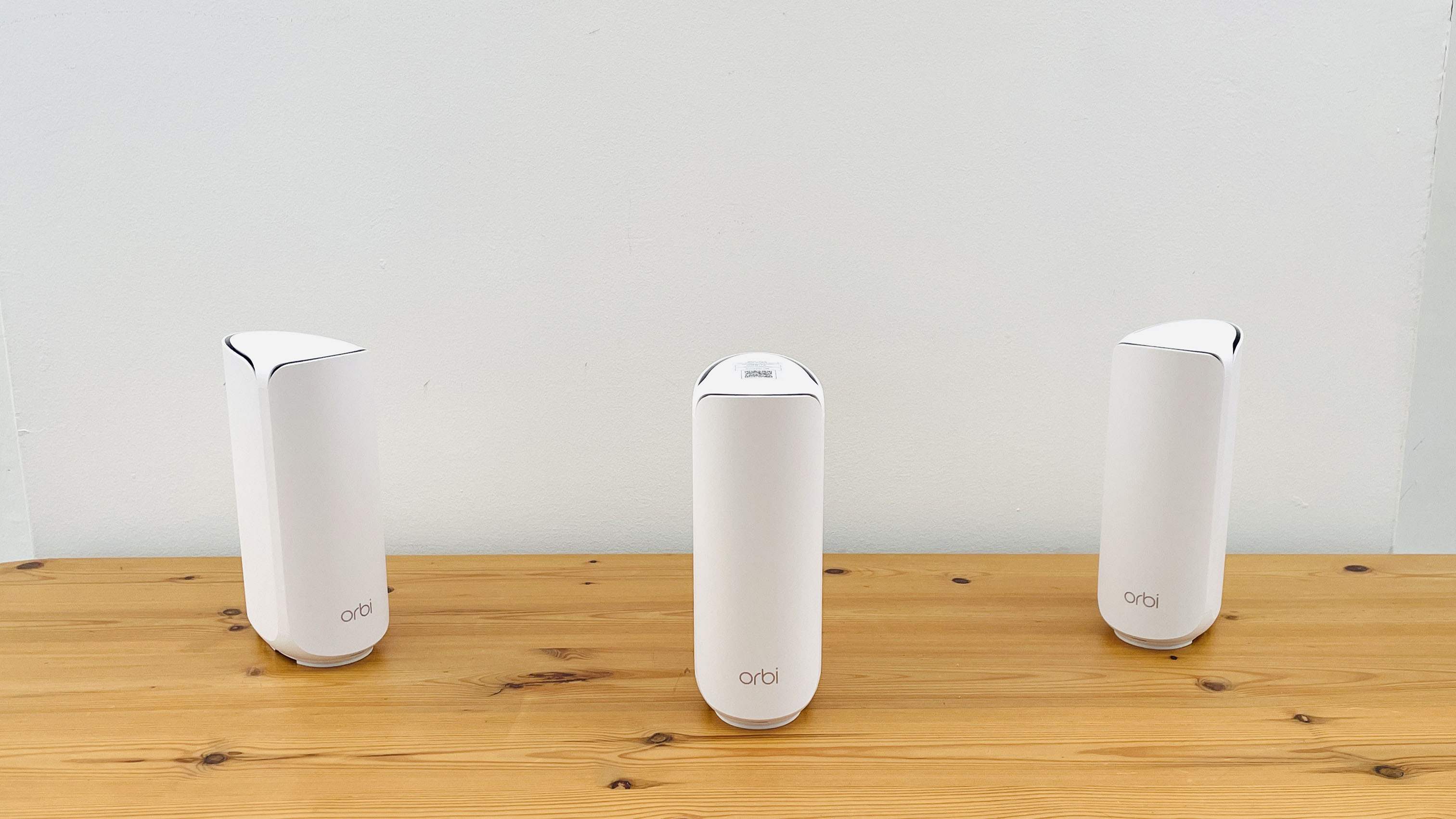 Netgear Orbi 373 with one router and two satellites on a wooden table