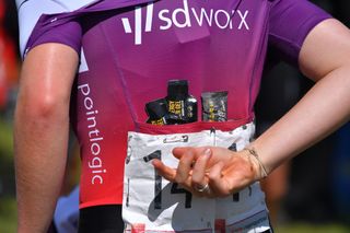 Image shows a SD Worx rider with gels in her jersey pocket.