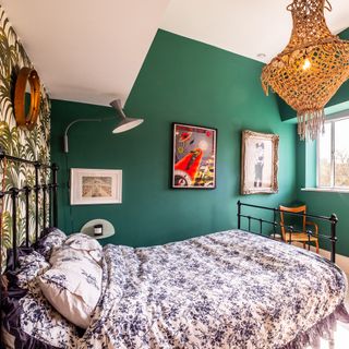 bedroom with frames on green wall bed