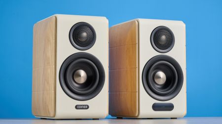the edifier s880db mkii speakers in white and wood colorway showing the connectivity options, remote control, against a blue background