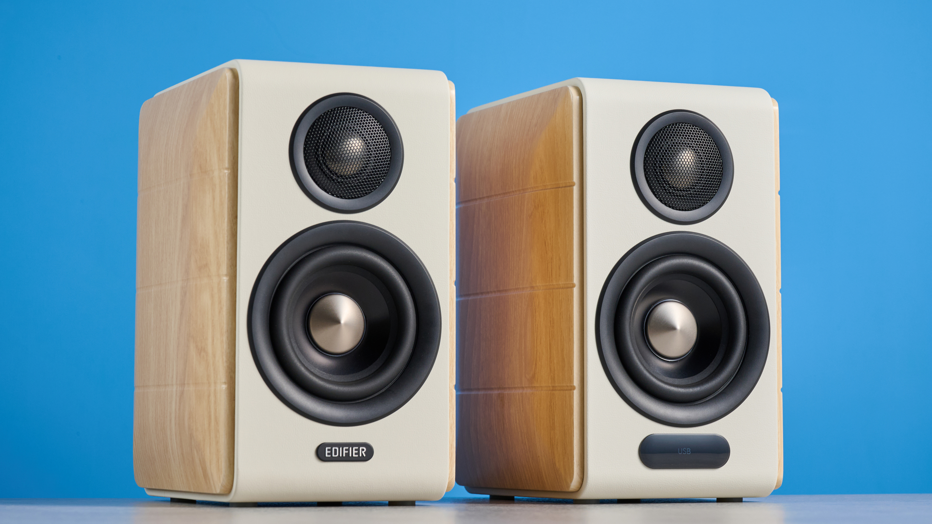 the edifier s880db mkii speakers in white and wood colorway showing the connectivity options, remote control, against a blue background
