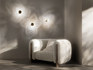 Lasvit lighting by Martin Gallo on wall beside chair
