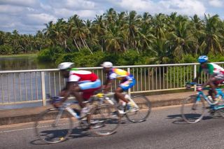 Riders cross a bridge on the coastal highway, one of the smoothest roads in Benin.
