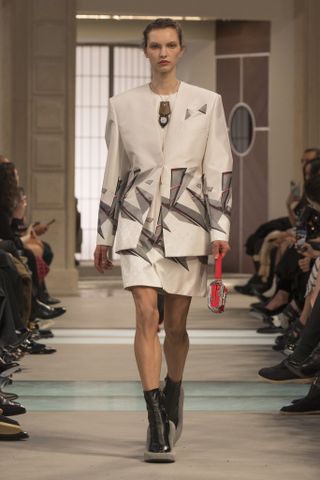 A model wearing a white, '80s-printed skirt suit at the F/W 25 Louis Vuitton show.