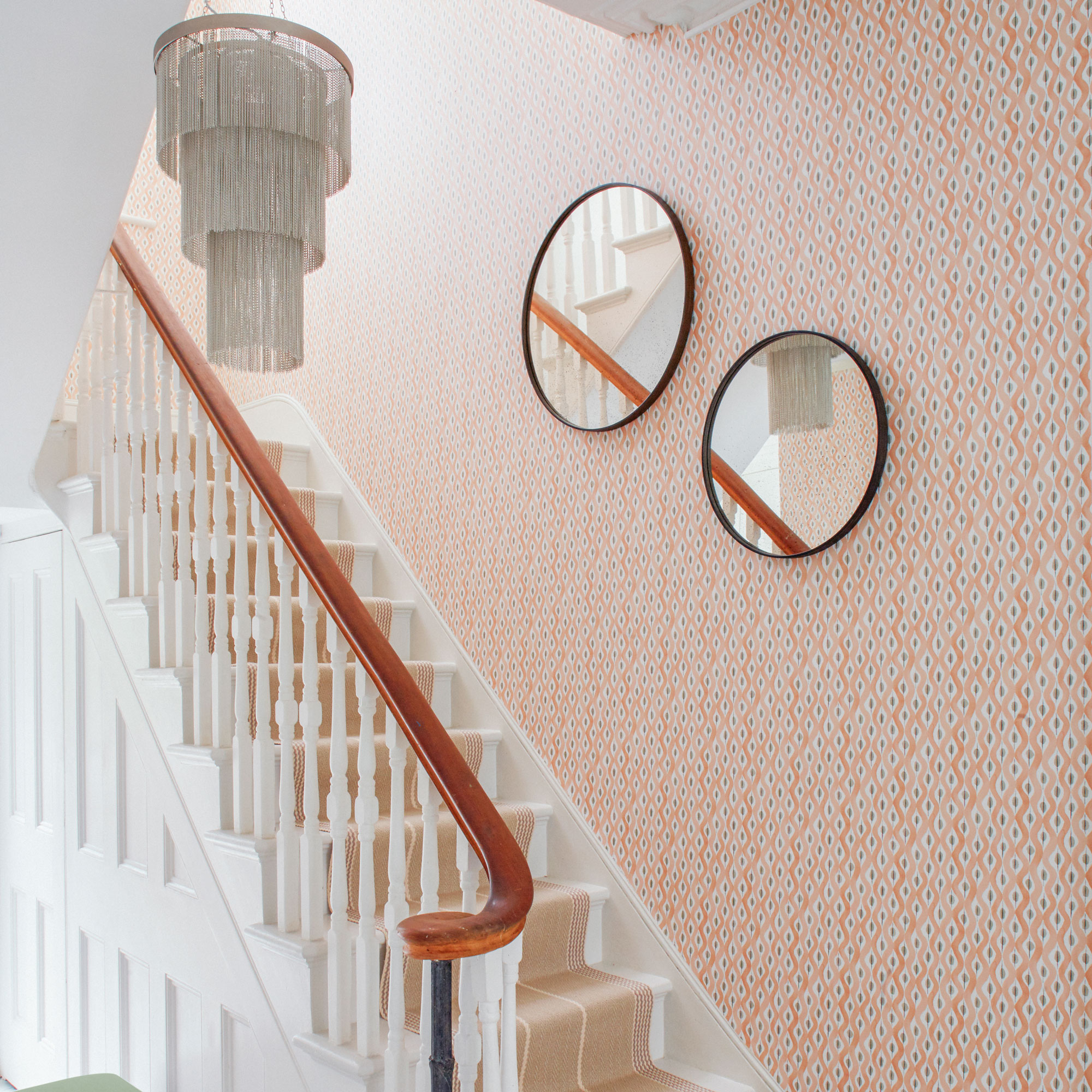 Pink pattern wallpaper and silver chandelier