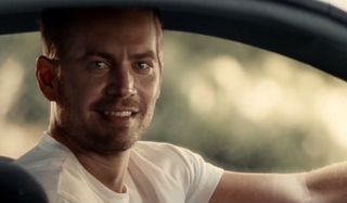 Paul Walker smiling behind the wheel in Furious 7.