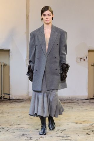 a Carven model wearing a pair of glove boots on the fall/winter 2024 runway