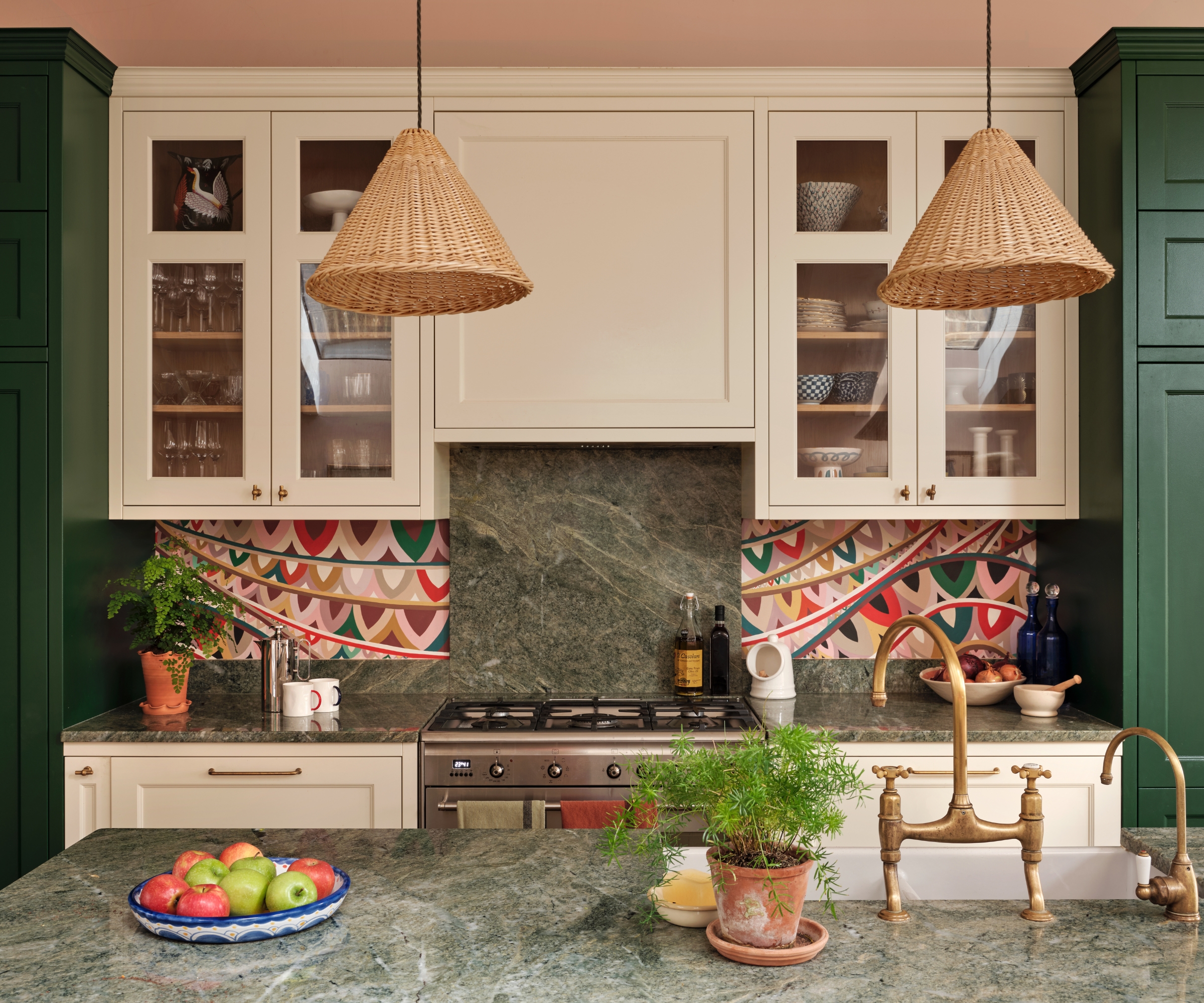 A green and white kitchen with a mixed material backsplash