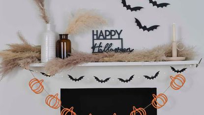 Halloween home decorations on mantle piece with bunting and candle holder 