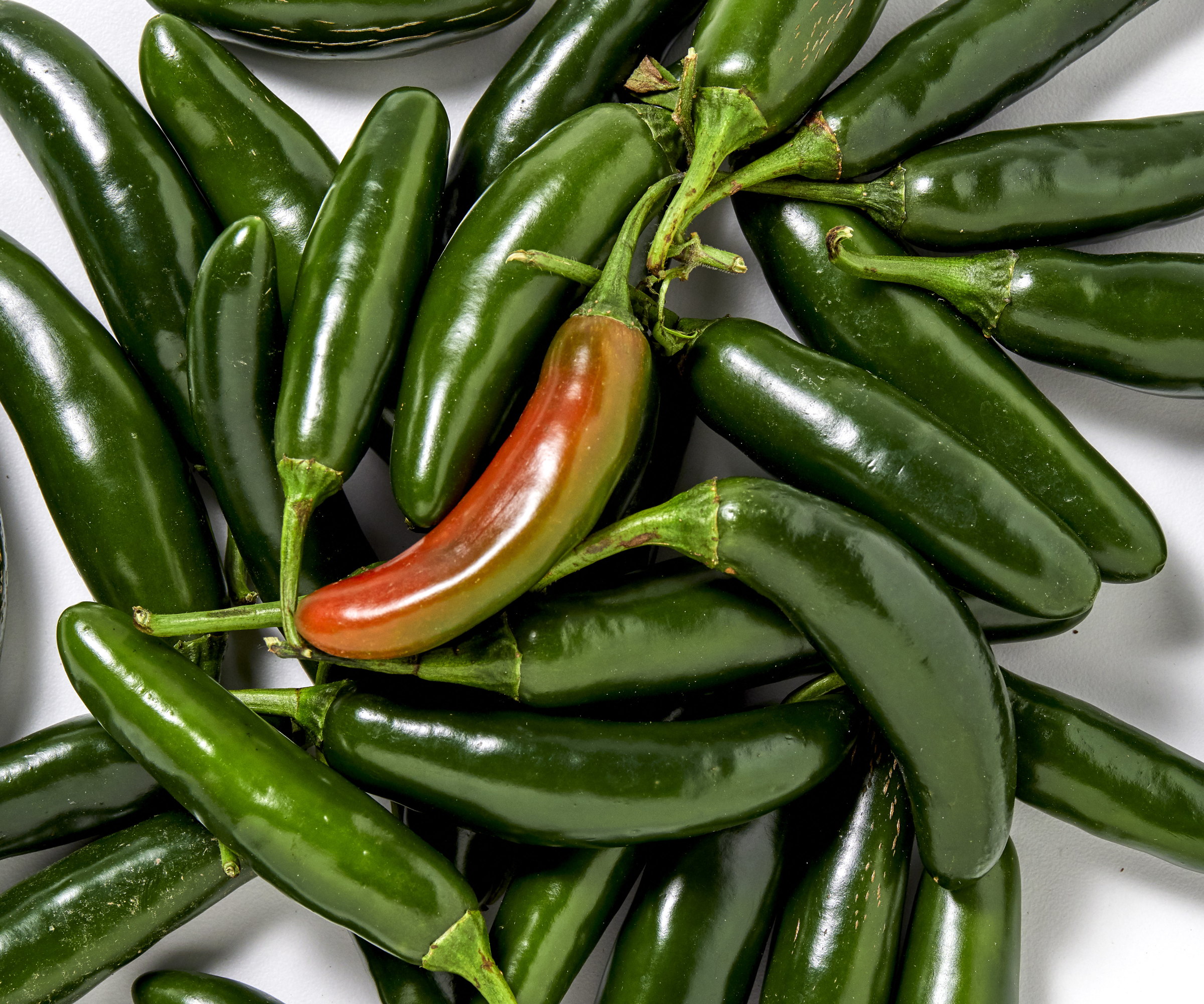 Red and green serrano peppers piled up