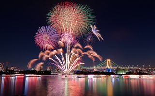 Fireworks explode above Tokyo Bay on November 23, 2013 in Tokyo, Japan.Odaiba fireworks display with Rainbow Bridge lit up in rainbow colors.