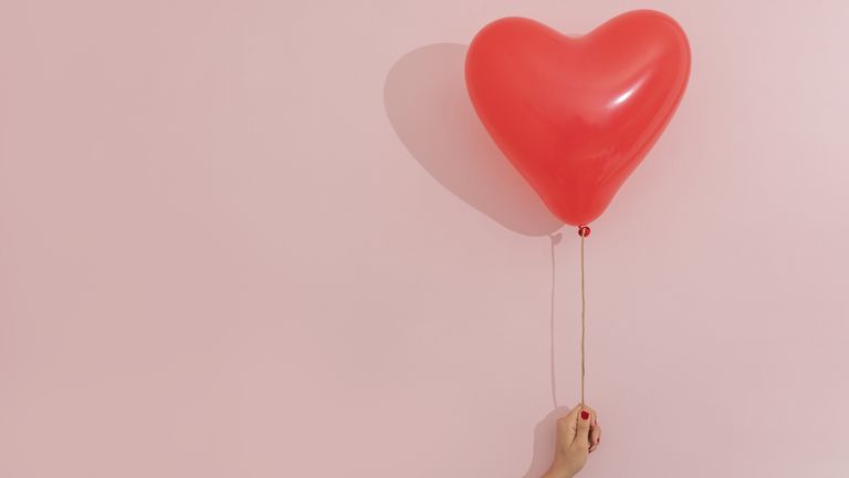 red heart-shaped balloon on pink background