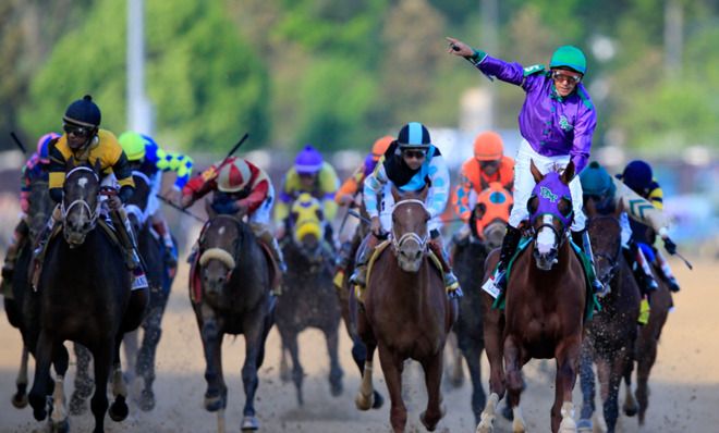 Jockey Victor Espinoza celebrates as California Chrome crosses the finish line to win the Kentucky Derby