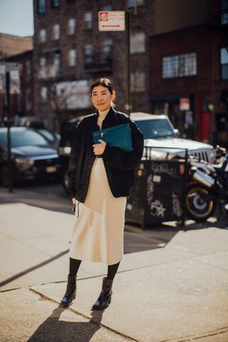 woman wearing leather jacket, dress, and boots