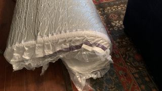 Purple Plus Mattress wrapped in vacuum-packed packaging and placed on our reviewer's carper