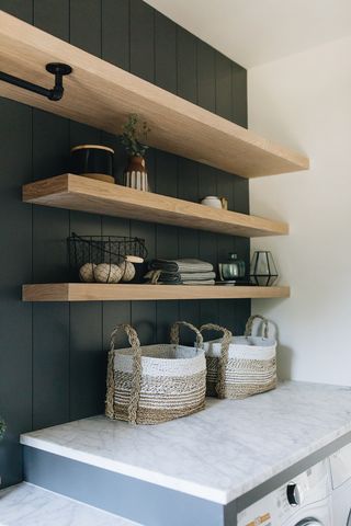 laundry room with black shiplap and wood shelving