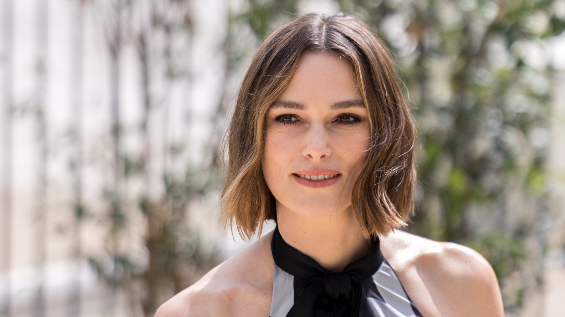 a white woman with short, brown hair posing for a photo outside