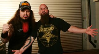 Dimebag Darrell and Kerry King of Slayer pose backstage in 2004. King wears a Venom T-shirt. Dimebag wears a ballcap and has his beard dyed bright red.