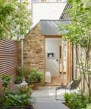 A side garden transformed into a useable space with paving and pot plants