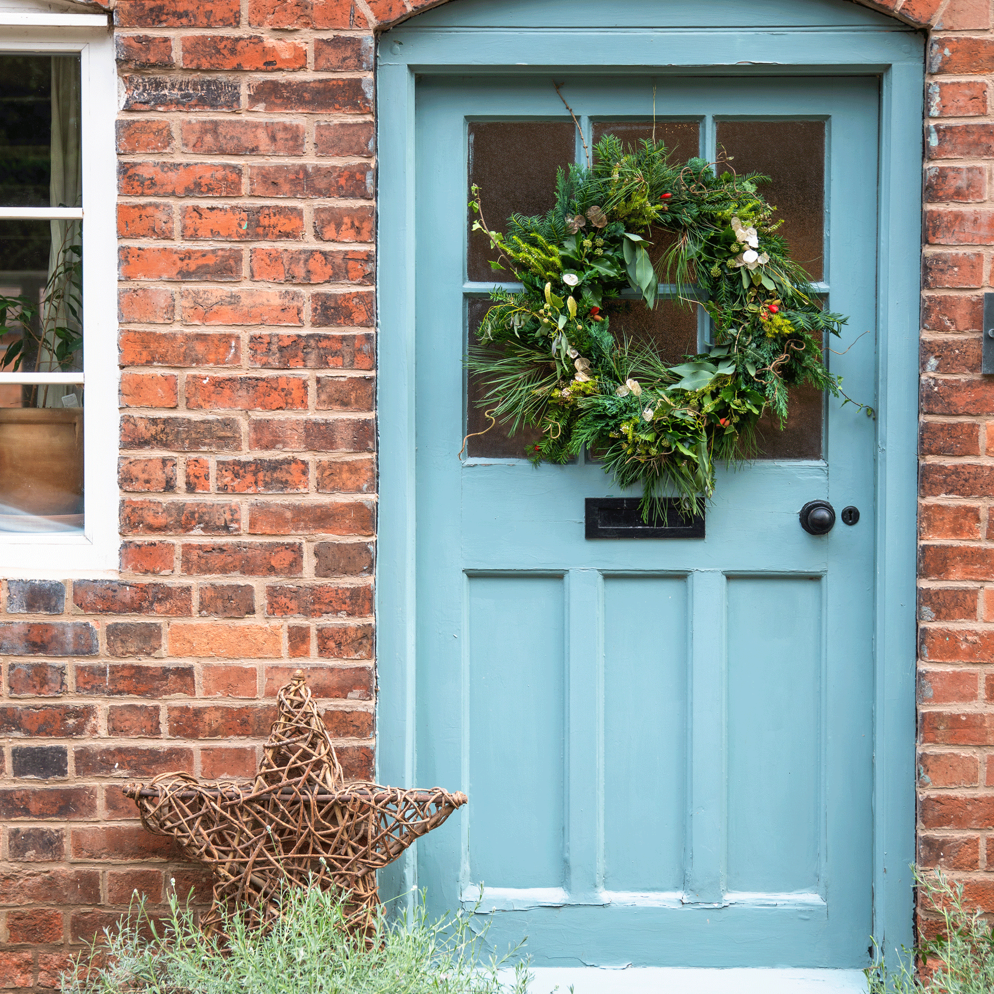 a blue front door with a festive wreath