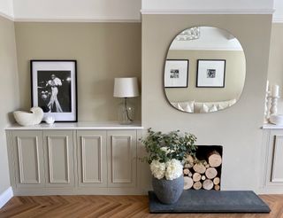 beige cabinets in a living room with a big round mirror