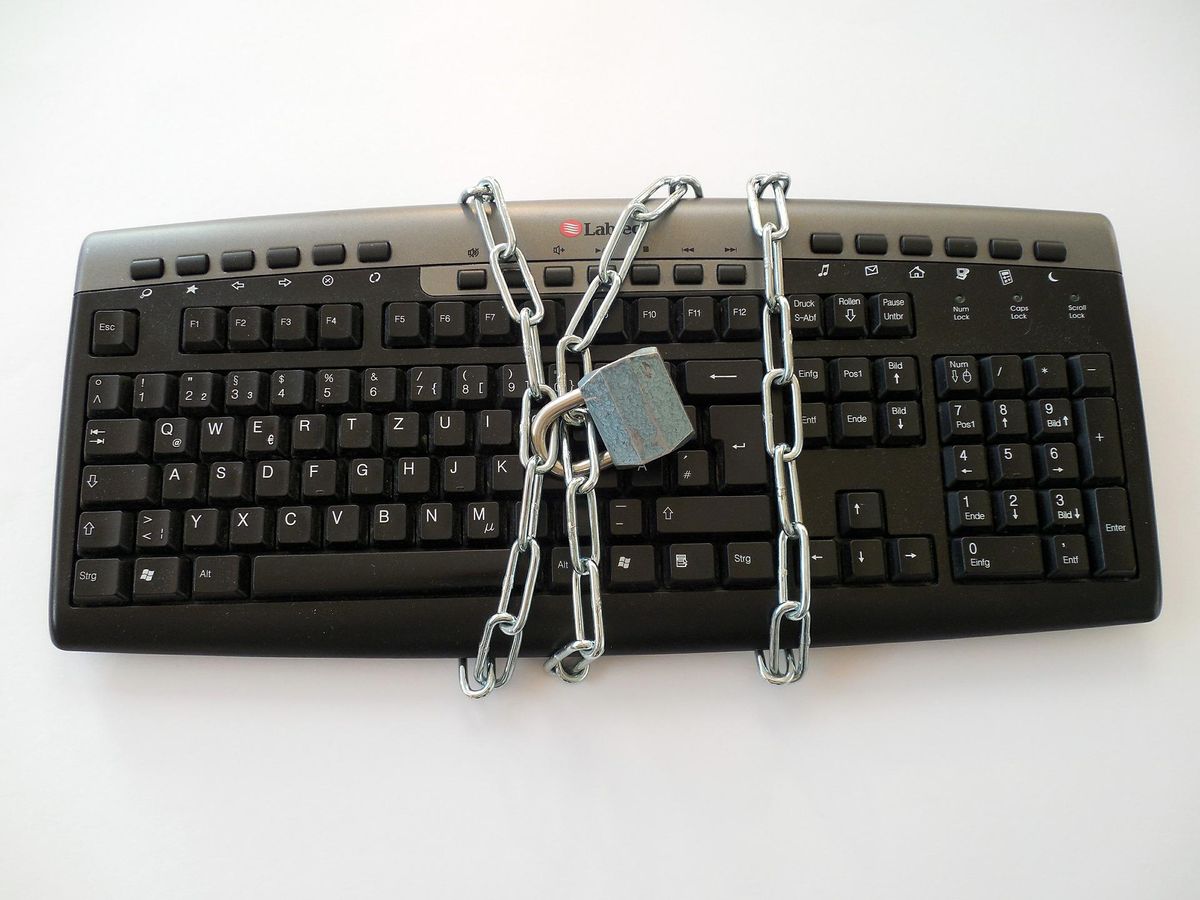 A keyboard tied in a chain with a lock.