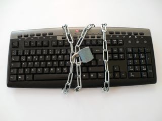 A keyboard tied in a chain with a lock.