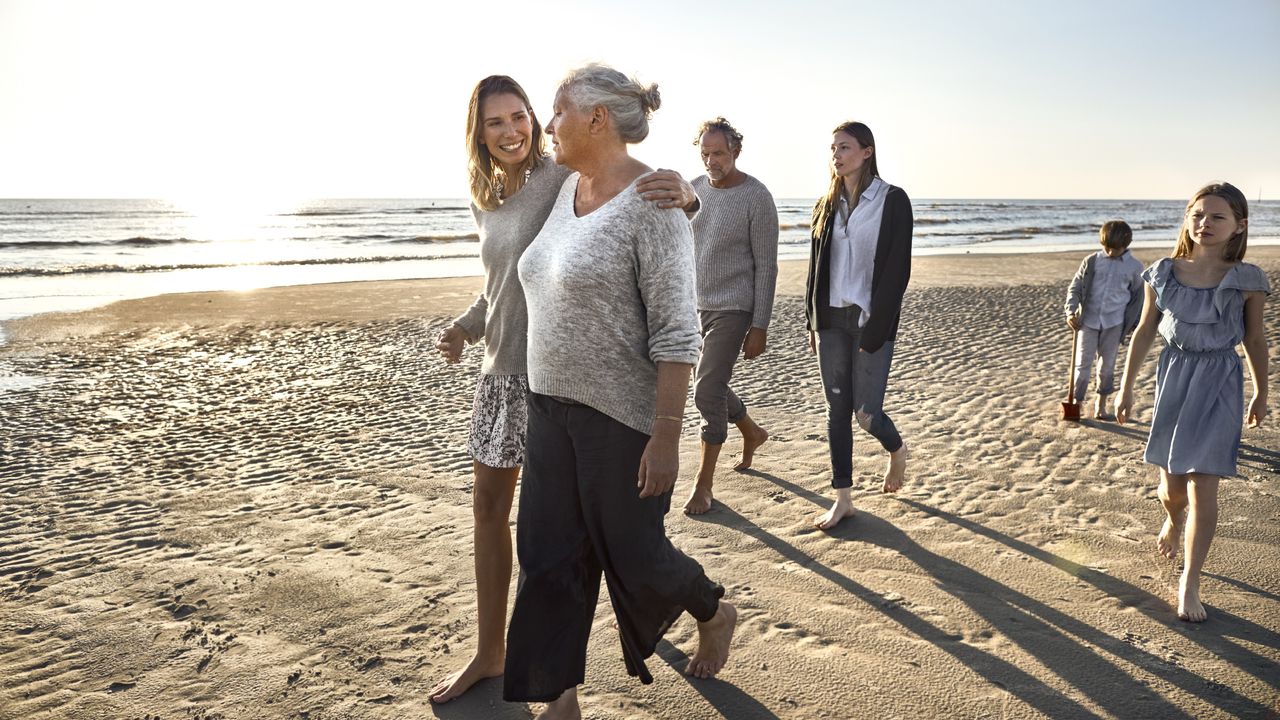 An extended family walk together on the beach.