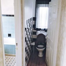 bathroom with toilet and black and white tiles