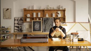 A creative sits by an Elegoo Phecda engraver in his workshop