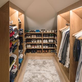 Walk-in wardrobe in loft area with shoe storage and open wardrobes for clothes