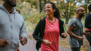 Woman jogging next to friends laughing and smiling