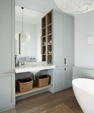 bathroom with tub and vertical storage with baskets under the vanity area