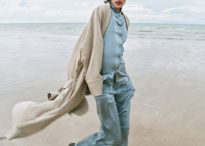 Woman on beach in loungewear pyjamas and cardigan