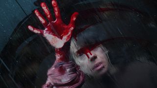 Sally Hawkins in Bring Her Back, holding her bloody hand up against a window 