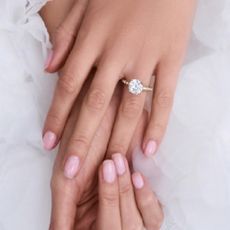 A hand wearing a Kay Jewelry lab-created diamond engagement ring on a white background