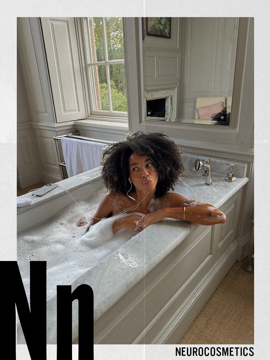 A woman in a marble bath listening to music with headphones in