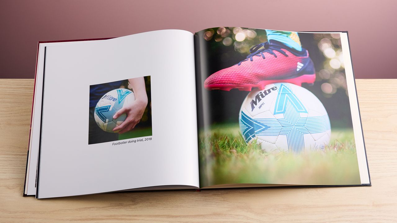 Person holding football and boot on top of football in Cewe photo book