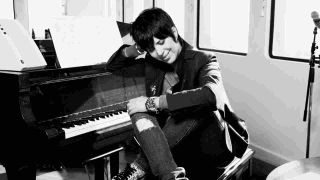 Diane Warren posing for a photograph at a piano