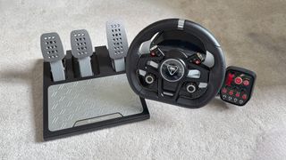 Turtle Beach VelocityOne Race on a carpet next to its pedals