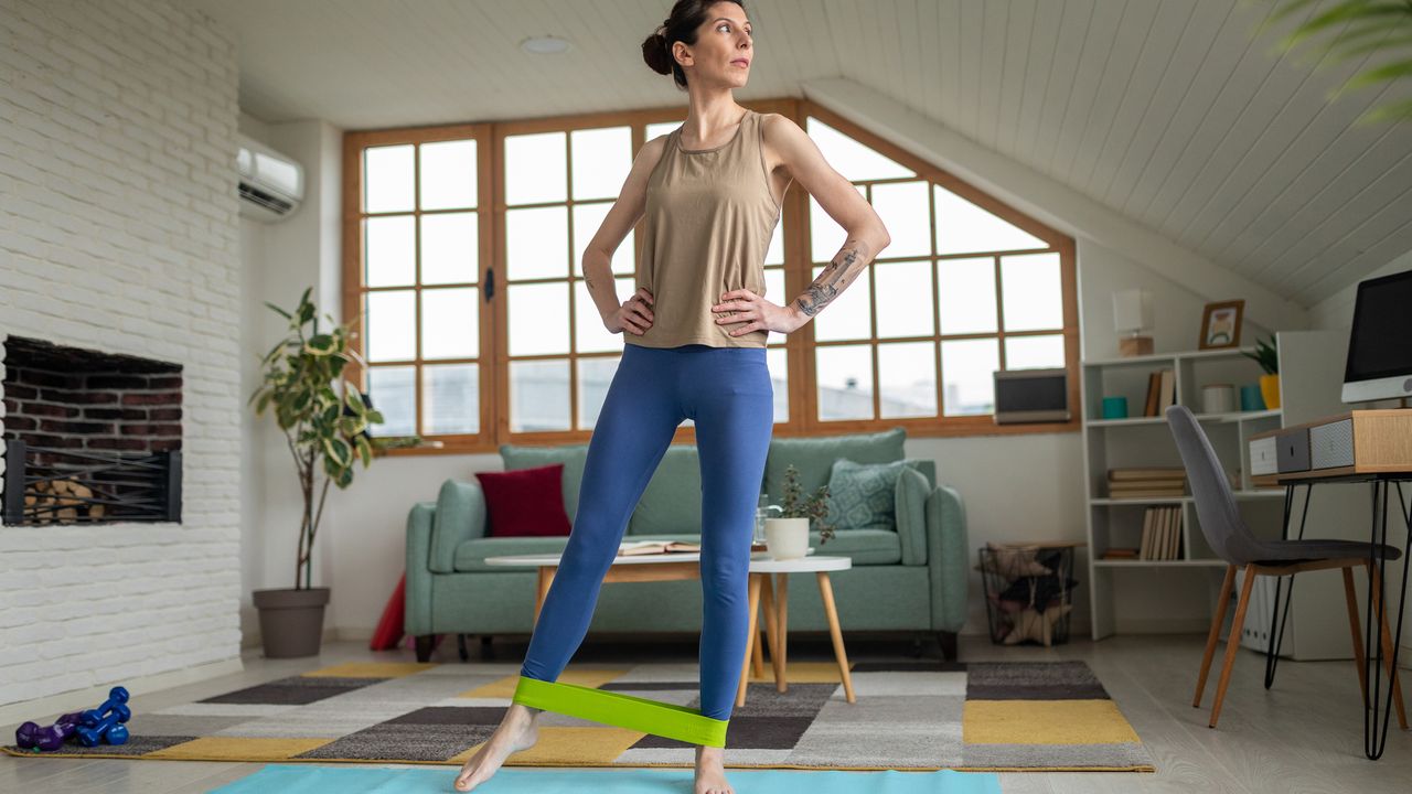 Woman exercising at home with resistance band