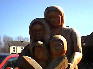 Low-res photo of a statue of a family under a blue sky