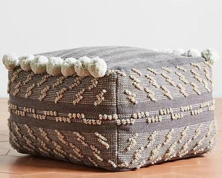 Anthropologie grey outdoor cushion pouf with pom poms