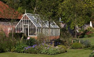 traditional brick and glass greenhouse in walled garden